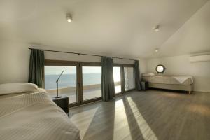 een slaapkamer met een bed en uitzicht op de oceaan bij Eosea Selene in Ierissos