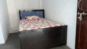 a small bed in a corner of a room at Prime Hotel in Kannauj +1 photo