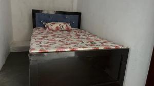 a bed with a black frame and a bed with flowers on it at Prime Hotel in Kannauj