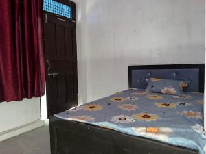 a bedroom with a bed with a blue comforter at Prime Hotel in Kannauj