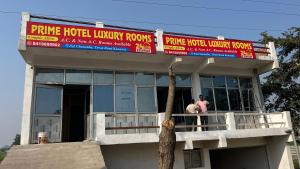 a man and woman standing on the balcony of a building at Prime Hotel in Kannauj