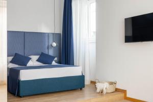 a bedroom with a blue and white bed and a tv at Boutique Hotel Maria Vittoria in Rome