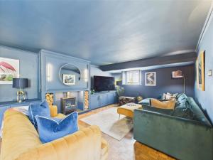 a blue living room with a couch and a tv at Smithy Stables in Barnard Castle