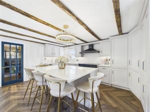 a kitchen with white cabinets and a white table and chairs at Smithy Stables in Barnard Castle