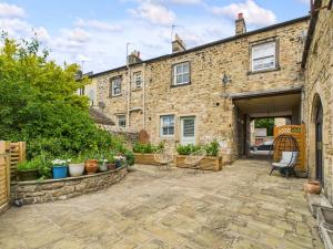 a stone building with chairs and a patio at Smithy Stables in Barnard Castle