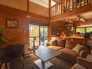 een woonkamer met een bank en een tafel bij Kurokawa Mori No Kiki in Minamioguni