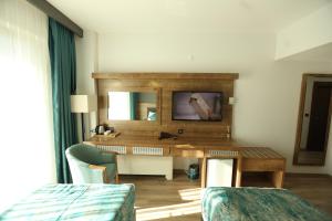 a hotel room with a desk and a mirror at Lina Garden Otel in Bingol