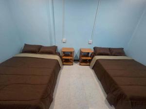a room with two beds and two tables at Mook Lucky family in Ban Chao Mai