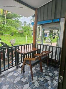 een patio met een tafel en banken op een balkon bij KohmookLuckyfamily in Ban Chao Mai