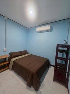 een slaapkamer met een bed en een blauwe muur bij KohmookLuckyfamily in Ban Chao Mai