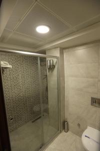 a bathroom with a shower and a toilet at Lina Garden Otel in Bingol +17 photos