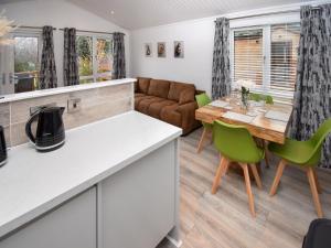 une cuisine et un salon avec une table et des chaises dans l'établissement Bluebird Lodge 2 - Uk50932, à High Nibthwaite