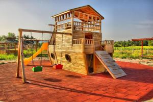 een houten speelplaats met een glijbaan en een speeltuin bij Dardanos Yerleşkesi in Hamidiye