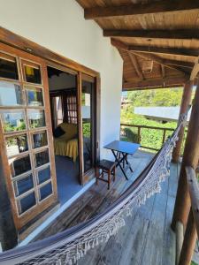 a hammock on the porch of a house at Casablanca do Rosa in Praia do Rosa