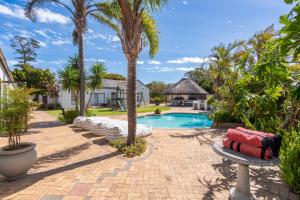 a resort with a swimming pool and palm trees at 2 On Lismore Guesthouse in Tokai