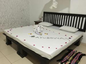 un letto in una stanza con dei fiori di Greenwood Hotel Sigiriya a Sigiriya