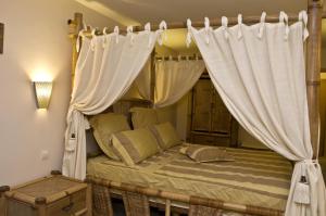 a bedroom with a canopy bed with white curtains at Hotel 4 Zona in Sofia