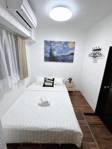 a bedroom with a large white bed in a room at Katsu hotel 3号机场直通 in Osaka