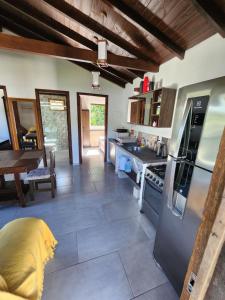 a kitchen with a stove top oven next to a table at Casablanca do Rosa in Praia do Rosa