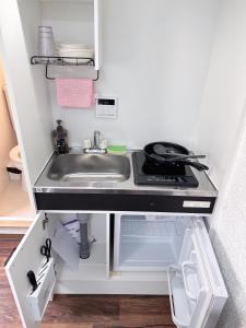 a small kitchen with a sink and a stove at Katsu hotel 3号机场直通 in Osaka