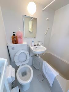 a white bathroom with a toilet and a sink at Katsu hotel 3号机场直通 in Osaka +12 photos
