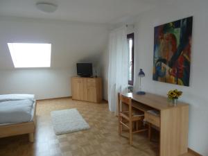 ein Schlafzimmer mit einem Schreibtisch und einem Bett sowie ein Zimmer mit einem Schreibtisch in der Unterkunft Apartmentvermietung Berg in Witten