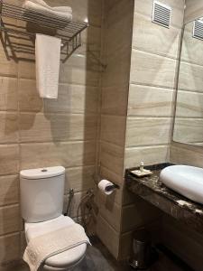 a bathroom with a white toilet and a sink at Hotel A44 in Tetouan