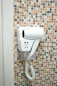 a white phone hanging on a wall in a bathroom at B&B A Da Ziett Suite in Naples