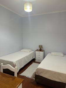 a bedroom with two beds and a table and a nightstand at Apartamentos Amarelo in Caniçal