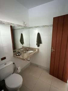 a bathroom with a toilet and a sink and a mirror at refugio buzios in Búzios +12 photos