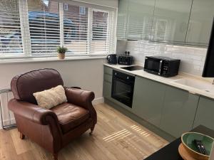 eine Küche mit Lederstuhl und Mikrowelle in der Unterkunft Modern & Cozy Studio Apartment in Andover in Andover