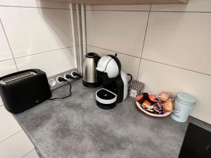 a kitchen counter with a coffee maker and a plate of food at Le Cocon Commerçien in Commercy