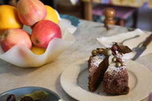a table with two pieces of cake and a bowl of fruit at B&B L'uva Fragolina in Reggio Emilia