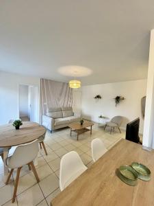 ein Wohnzimmer mit einem Tisch und einem Sofa in der Unterkunft L'écrin Lensois - 57 m2 - 6 personnes - parking in Lens