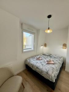 ein Schlafzimmer mit einem Bett, einem Fenster und einem Stuhl in der Unterkunft L'écrin Lensois - 57 m2 - 6 personnes - parking in Lens