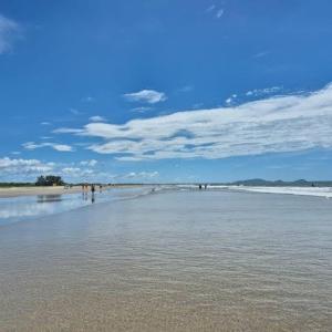 eine Gruppe von Menschen, die am Strand spazieren gehen in der Unterkunft KitNet suíte Balneário shangrila in Pontal do Paraná