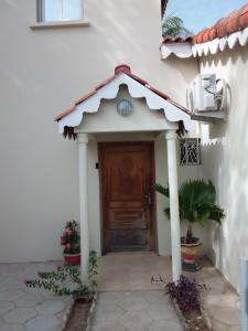 een ingang van een wit huis met een houten deur bij Résidence Diamane Sokone in Sokone