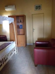 een kamer met een bed, een bank en een deur bij Résidence Diamane Sokone in Sokone