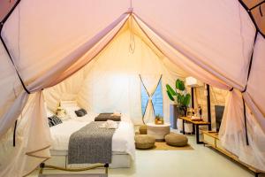 een slaapkamer met een bed in een tent bij Camping&Cafe Khao Phratamnak in Pattaya South +21 foto's