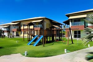 un parco giochi con scivolo di fronte a un edificio di Village Baixio Frente ao mar a Baixio