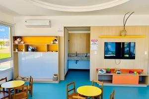 una sala con tavoli e sedie e una cucina di Village Baixio Frente ao mar a Baixio