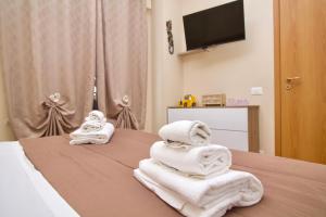 een kamer met handdoeken op een bed en een televisie bij Raggio di Sole Apartment in Valmontone