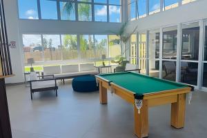 un tavolo da biliardo in una grande stanza con finestre di Village Baixio Frente ao mar a Baixio