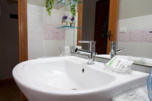 een witte wastafel in een badkamer met een spiegel bij Raggio di Sole Apartment in Valmontone