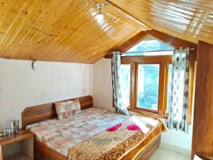 a bedroom with a bed in a room with a window at Happy Mountains in Nārkanda