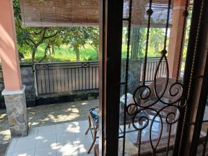an open door to a porch with a bench at Mangga in Sengkaling