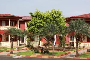 a red building with palm trees in front of it at Complejo Caribe in Monte Alen