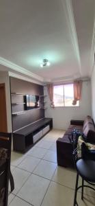 a living room with a couch and a flat screen tv at Apartamento próximo Aeroporto Cuiabá in Várzea Grande