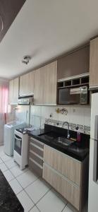a kitchen with a sink and a stove at Apartamento próximo Aeroporto Cuiabá in Várzea Grande