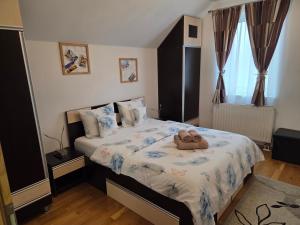 a bedroom with a bed with two towels on it at Smiley Apartment in Sibiu